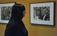 una visitante observando unas fotografías en la exposición